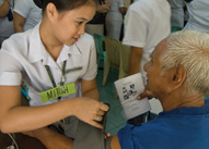 In Manila, a young nurse cares for an elderly patient, bringing nuturing and listening to her technical know-how.
